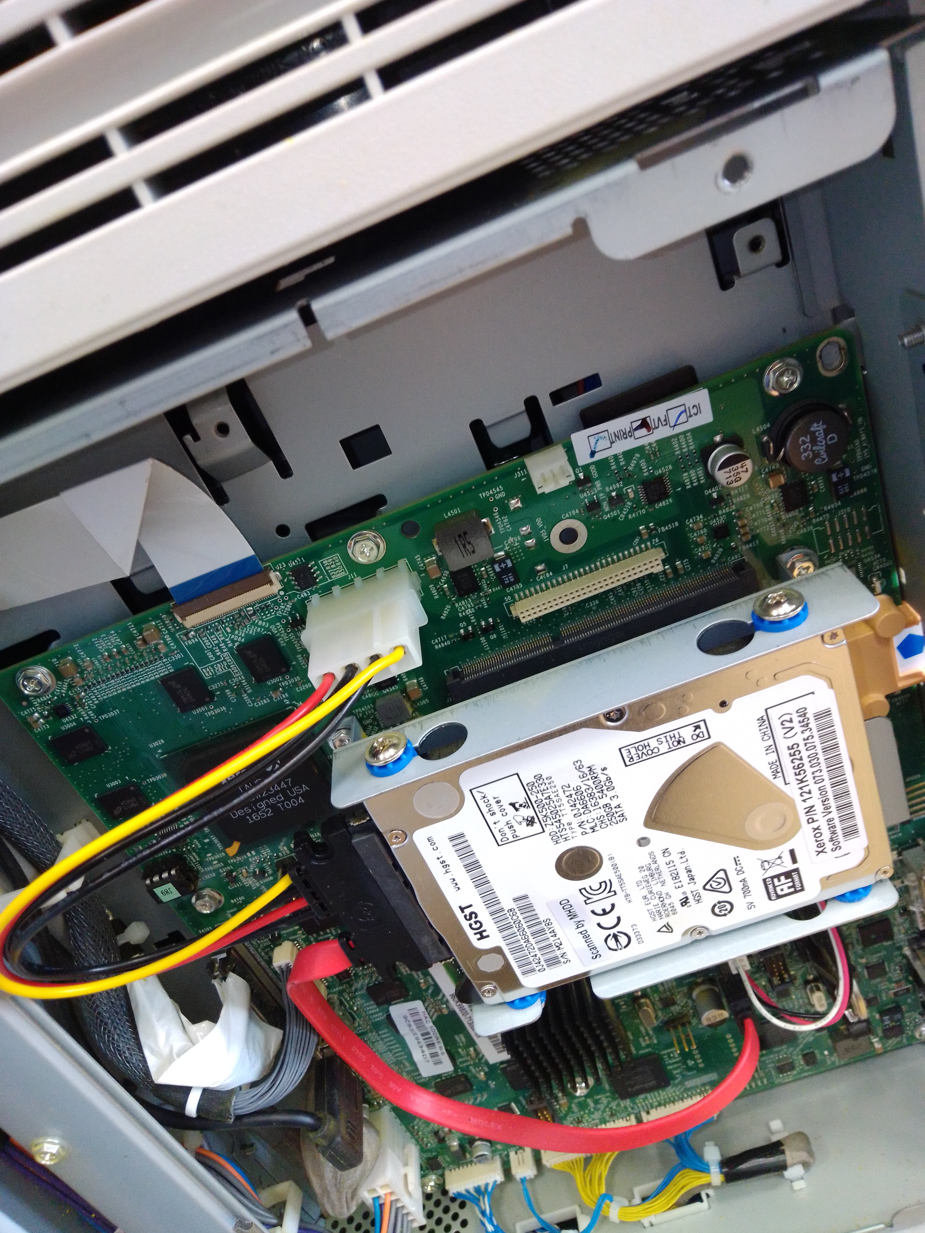 Жёсткий диск HGST, установленный внутри офисного принтера рядом с платой управления